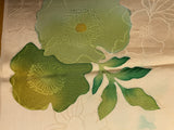 8105 Close-up of embroidered green flowers on beige fabric
