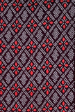 8148-Top half view, 1980s Japan Shibori dyed textile pattern featuring a repeating diamond and floral motif in red, white, and dark brown-black.