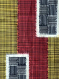 7976: Meisen Textured fabric with a checkered pattern in red, yellow, and black.