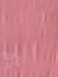 81132: 1980s Japan Kimono Silk A close-up of a pink textured fabric with subtle tonal floral patterns.