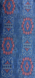8115:1980s Japan Ohshima Tsumugi bottom half view woven fabric with a repeating geometric and floral pattern in blue, rust red, and white.