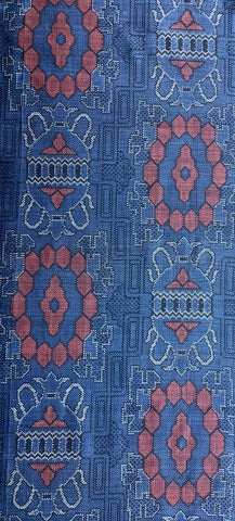 8115:1980s Japan Ohshima Tsumugi bottom half view woven fabric with a repeating geometric and floral pattern in blue, rust red, and white.