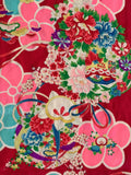 8129:  cloeup 4flowers, cords, drum 1930s Japan Ceremonial GIrls kimono deadstock silk fabric:  of a Japanese-style floral fabric pattern on a deep red background, featuring large pink and turquoise flowers with smaller multicolored blossoms and green leaves