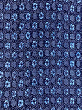 81332:A close-up of a woven fabric pattern featuring repeating blue and navy hexagonal motifs on a dark navy background.