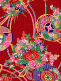 8144 1960s silk: A close-up of a Japanese kimono fabric pattern featuring a vibrant red background decorated with colorful floral bouquets, traditional circular medallions, and elegant curved lines in pink, green, blue, yellow, and white.